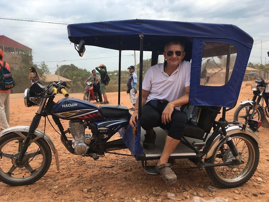 Mauricio Passaro sentado en un mototaxi azul durante un viaje por una zona rural, reflejando sencillez, apertura y conexión con distintas culturas.